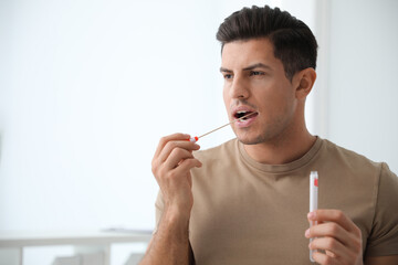 Man taking sample for DNA test indoors
