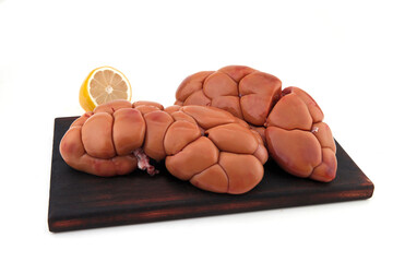 raw beef kidney on a cutting board isolated on a light background