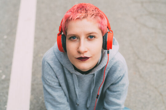Portrait of young happy woman outdoor listening music with headphones