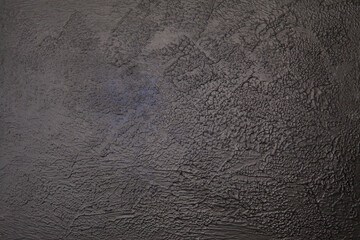 Dark textured concrete background with spot of light and blue tint