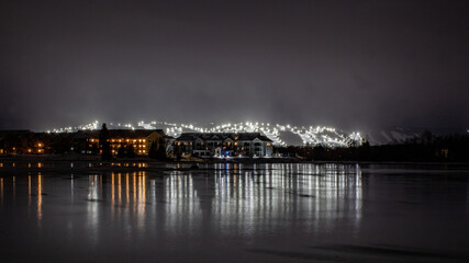 View of Blue Mountain ski resort and village from Lighthouse Point, Collingwood, Ontario. Ski runs are lit up for night skiing for skiers and snowboarders to ski at night during the winter