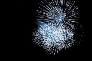 Luxury fireworks event sky show with blue big bang stars. Premium entertainment magic star firework at e.g. New Years Eve or Independence Day party celebration. Black dark night background