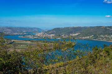 Obraz premium Panoramic view of the Rhone river meandering between Ardeche and Drome region with St-Vallier city underneath and mountains on the background.