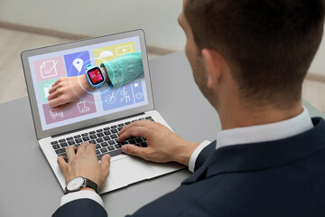 Control kid's geolocation via smart watch. Man using laptop at table, closeup