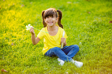 Fototapeta premium Cute little Indian girl summer on the lawn blowing soap bubbles