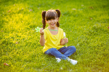 Fototapeta premium Cute little Indian girl summer on the lawn blowing soap bubbles