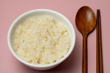 It is rice, the staple food of Koreans. Next to it, there are spoons and chopsticks, which are meal tools.
