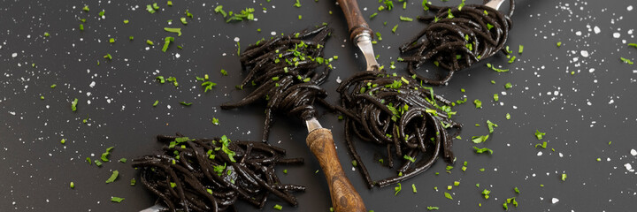 Black spaghetti pasta with Cuttlefish ink. Black seafood pasta on a dark background. Mediterranean delicacy food.