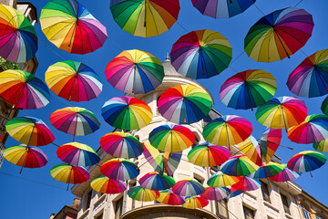 Floating colorful rainbow umbrellas are decorating Rue Carnot in the center of the city of Gap,...