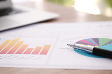 Paper document with charts and pen on table, closeup. Investment analysis