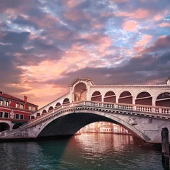 Foto op Plexiglas Rialtobrug Rialto bridge on The Grand Canal in Venice, Italy in the evening on sunset. Pink purple sky with clouds.Toned square image. Famous place, romantic sights of Venice in Italy.