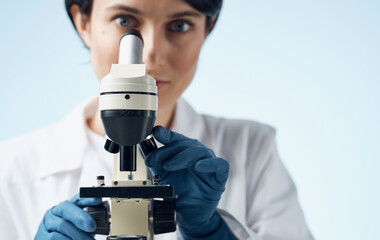 woman doctor in medical gloves and microscope on the table professional laboratory