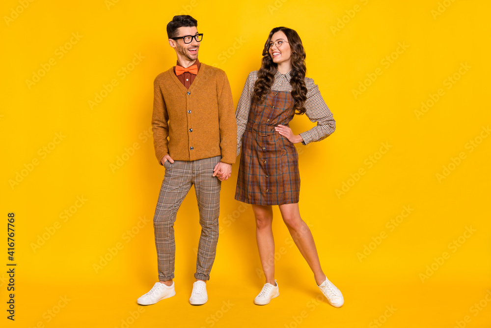 Wall mural Full length body size view of attractive cheerful couple holding hand having fun meet isolated on bright yellow color background