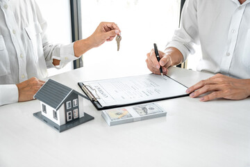 Real estate agent Sales manager holding filing keys to customer after signing rental lease contract of sale purchase agreement, concerning mortgage loan offer for and house insurance