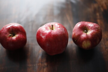 Jabłka czerwono mokre na brązowym stole