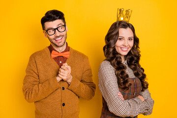 Portrait of attractive cheerful couple first meet date guy flirting girl wearing tiara isolated on bright yellow color background