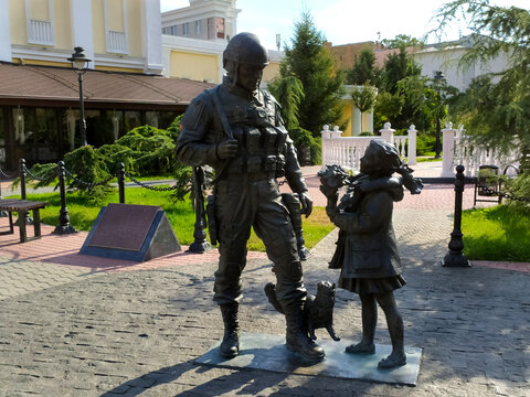 A sculpture of a soldier in camouflage and a girl with a cat, polite people, in Simferopol, Crimea. Travel concept. Horizontally. Mobile photo.
