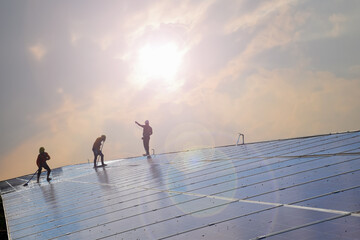 Solar panels or photovoltaic panels installed on the roof of the building which were washing the surface by workers to get high quality and use green and clean energy inside the building below.