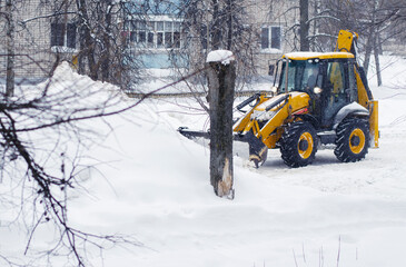 Tractor removes the snow. Snow clearing. Tractor clears the way after heavy snowfall.