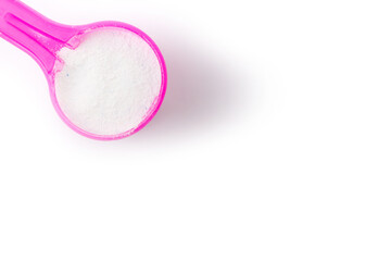 top view of washing powder in pink measuring spoon isolated on white background