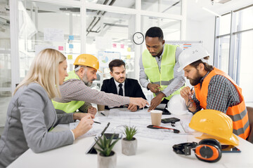 Multiracial team of businesspeople and architects working with drawings inspection