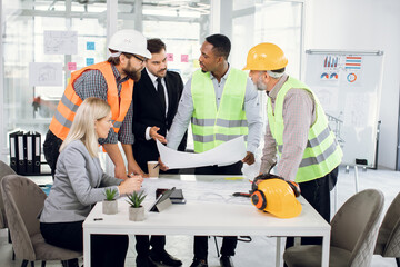 Diverse group of specialists working with blueprints