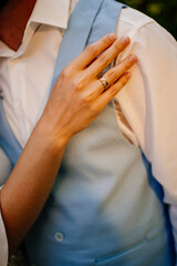 close-up details. bride and groom gently cuddle in park. touches.