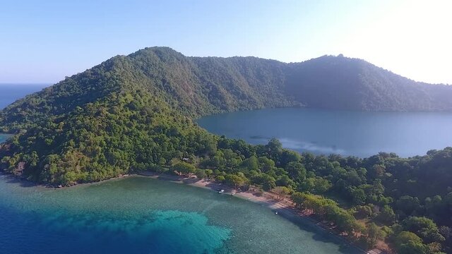 Aerial panorama of volcanic Satonda Island with caldera lake in East Indonesia