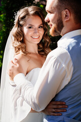 close up. Happy and beautiful bride and groom gently cuddle in park. touches.