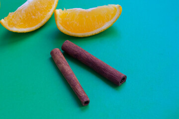 Orange and cinnamon on a green background, flat lay