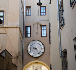 Fototapeta na wymiar Cozy facade of the building with big wall clock. Lviv Old Town, Ukraine