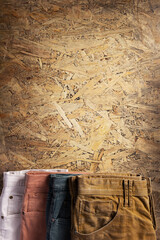 Denim jeans on old  chipboard wooden background texture table surface. Classic casual jeans