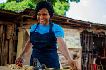 young pretty african female carpenter feeling as she is working in the store