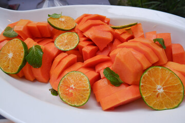 Fresh papaya slices and sweet orange on a plate. Healthy food