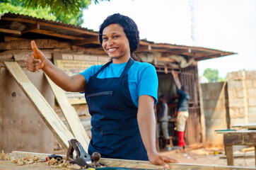 young pretty african female carpenter feeling excited as she did thumbs up