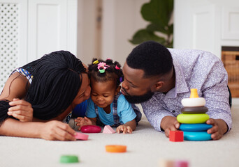 cute african american family having fun together on the carpet at home