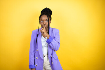 Young african american business woman asking to be quiet with finger on lips. Silence and secret concept.