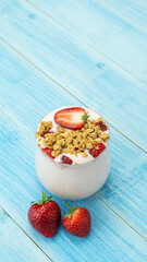 Strawberry yogurt on a blue wooden table.