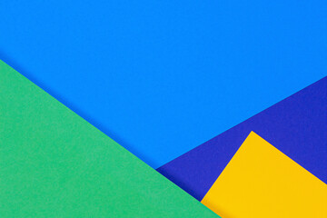 Creative abstract blue, green and yellow color geometric paper compositon background, top view