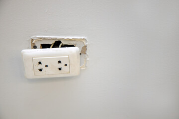 Broken dangerous electric outlet plug on the wall. Dangerous of electric from short circuits and...