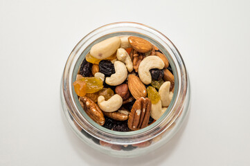 Nuts, candied fruits, dried berries in a glass bowl. Top view. Healthy vegeterian food. Cashews, Brazil nuts, raisins.