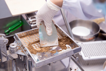 Apothecary or 
pharmacist contain dried herb powder to capsule filling machine with herbal medicine...