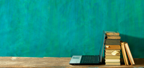 Stack of books and laptop computer,home office, homeschooling,reading,education, business concept....