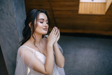 Wedding preparations. Beautiful young bride in white wedding dress indoors.