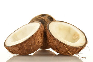One whole and two halves of ripe organic coconut, close-up, isolated on white.