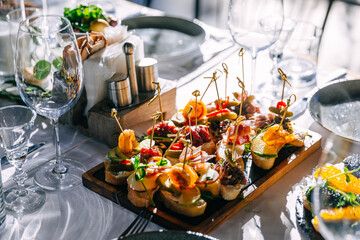 Different canapes with smoked salmon, cucumber cherry tomatoes and mozzarella served on a table.