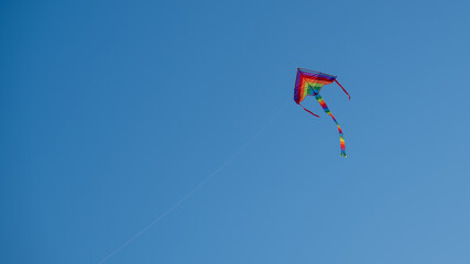 Air colored kite flying in the blue sky, Horizontal orientation, copy space.