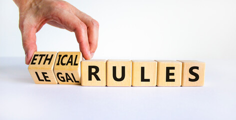 Ethical or legal rules symbol. Businessman turns wooden cubes and changes words ethical rules to...