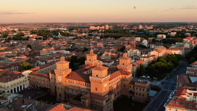 ferrara city center aerial view drone flying over estense castle at sunrise dawn
