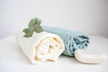 white and green towels, soap, and a branch of eucalyptus. skin care, home spa